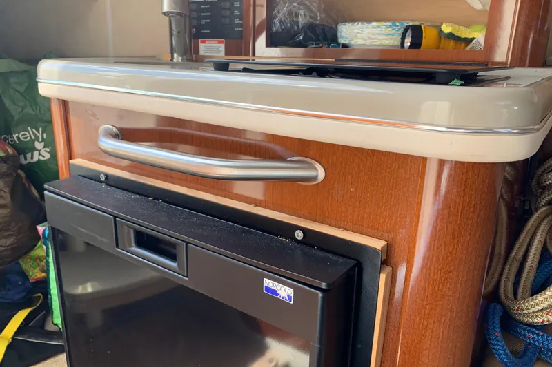 Slide: The Image of Interior view of a 2012 Sea Ray 240 Sundancer boat kitchenette with fridge and storage. - 23