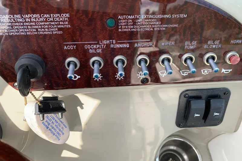Slide: The Image of Control panel of a 2012 Sea Ray 240 Sundancer boat with labeled switches and key. - 27