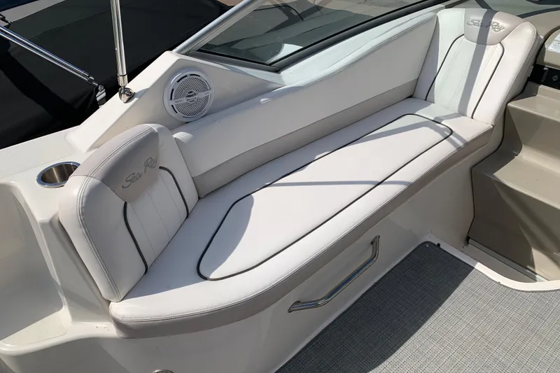 Slide: The Image of Luxurious seating on a 2012 Sea Ray 240 Sundancer boat, featuring white upholstery and speaker. - 30