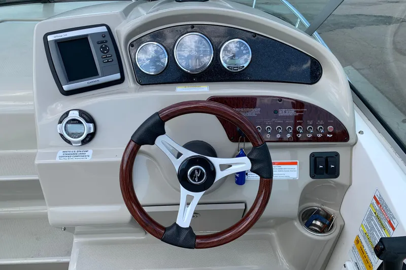 Slide: The Image of Dashboard of a 2012 Sea Ray 240 Sundancer boat with steering wheel and gauges. - 8