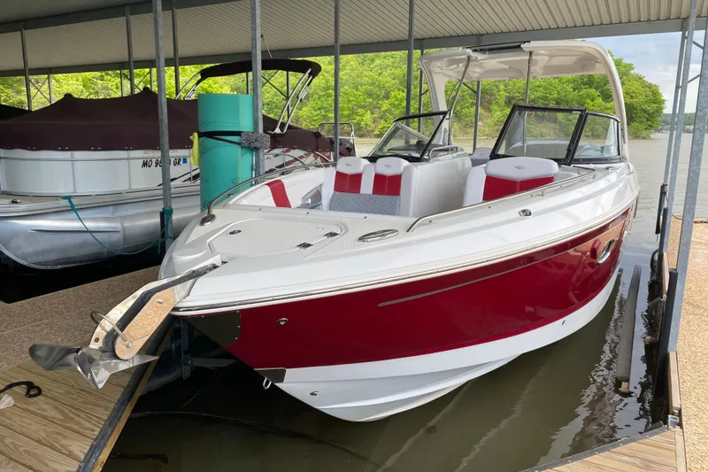 Slide: The Image of 2012 Chaparral 327 SSX boat docked, featuring a sleek red and white design. - 11