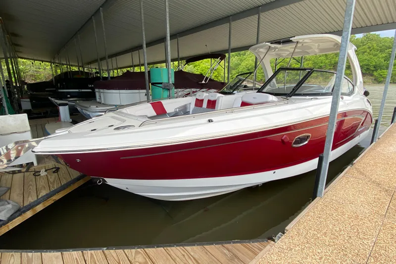 Slide: The Image of 2012 Chaparral 327 SSX boat docked, featuring a sleek red and white design. - 12