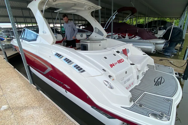 Slide: The Image of 2012 Chaparral 327 SSX boat docked, featuring sleek design and red accents. - 13