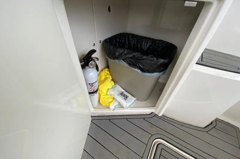 Slide: The Image of Storage compartment in 2012 Chaparral 327 SSX with fire extinguisher and trash bin. - 21