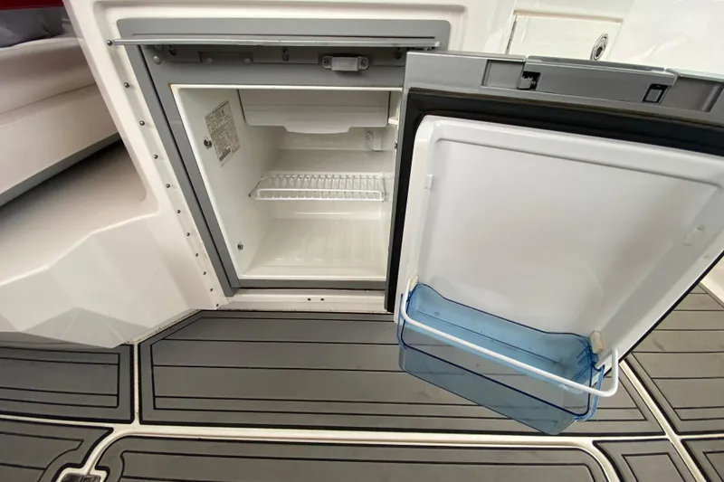Slide: The Image of Open refrigerator on 2012 Chaparral 327 SSX boat, showing interior shelving and door storage. - 22