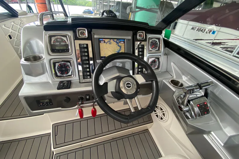 Slide: The Image of Cockpit of 2012 Chaparral 327 SSX boat with steering wheel and navigation controls. - 32