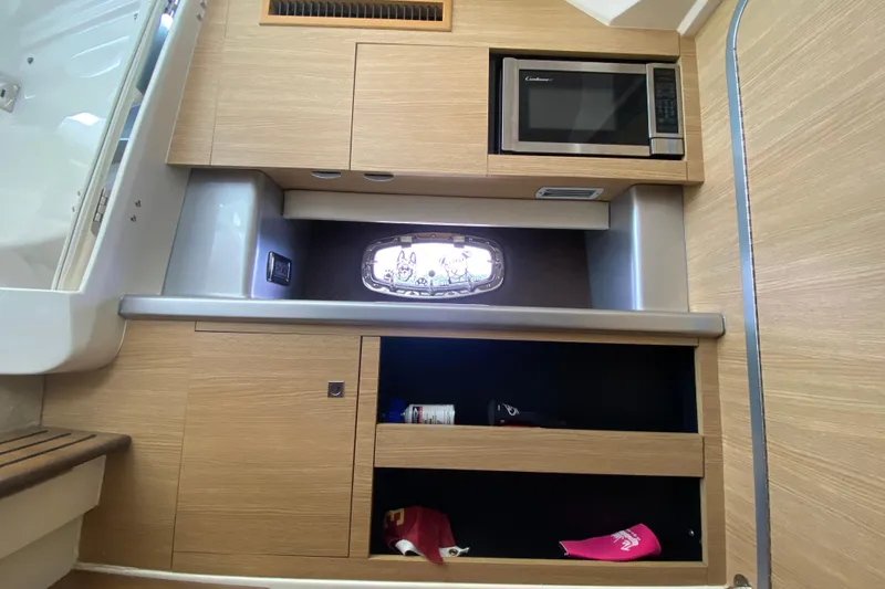 Slide: The Image of 2012 Chaparral 327 SSX interior with microwave and storage cabinets. - 43