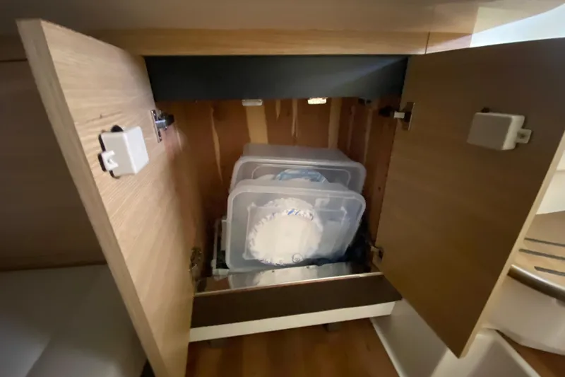 Slide: The Image of Cabinet storage on 2012 Chaparral 327 SSX boat with organized containers inside. - 44