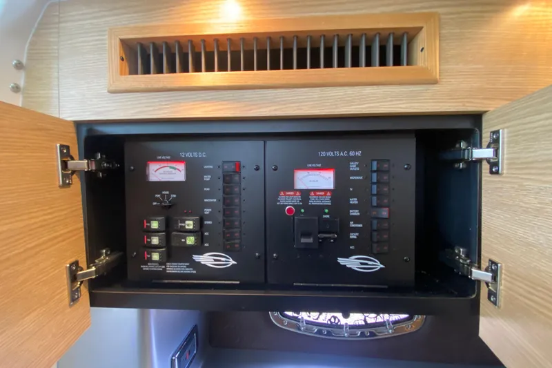 Slide: The Image of Electrical control panel inside a 2012 Chaparral 327 SSX boat, featuring voltage meters and switches. - 46