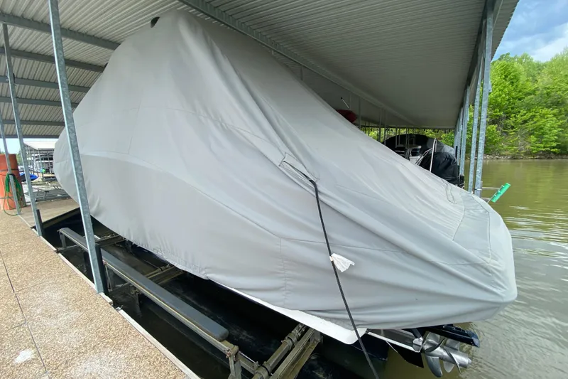 Slide: The Image of Covered 2012 Chaparral 327 SSX boat docked under a metal roof by the water. - 52