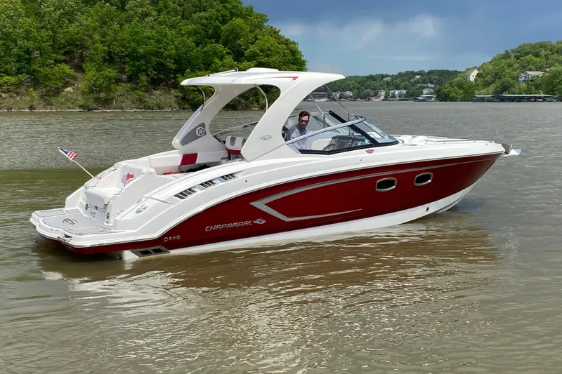 Slide: The Image of 2012 Chaparral 327 SSX boat cruising on a scenic river with lush green surroundings. - 8