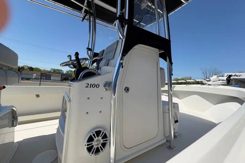 Slide: The Image of 2016 Parker 2100 Center Console boat with steering wheel and storage compartment. - 13