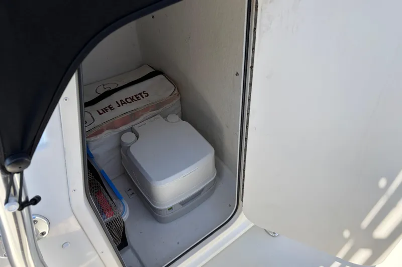 Slide: The Image of Storage compartment in 2016 Parker 2100 Center Console with life jackets and portable toilet. - 14