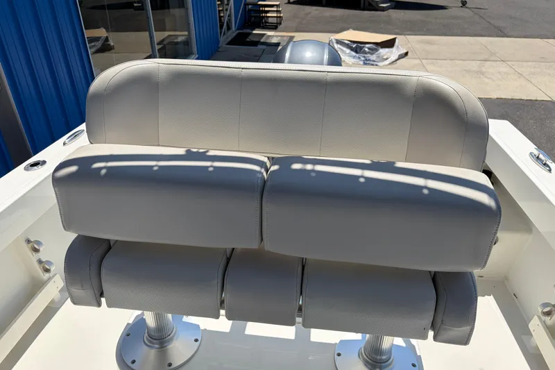 Slide: The Image of 2016 Parker 2100 Center Console boat seat, white upholstery, outdoor setting. - 16