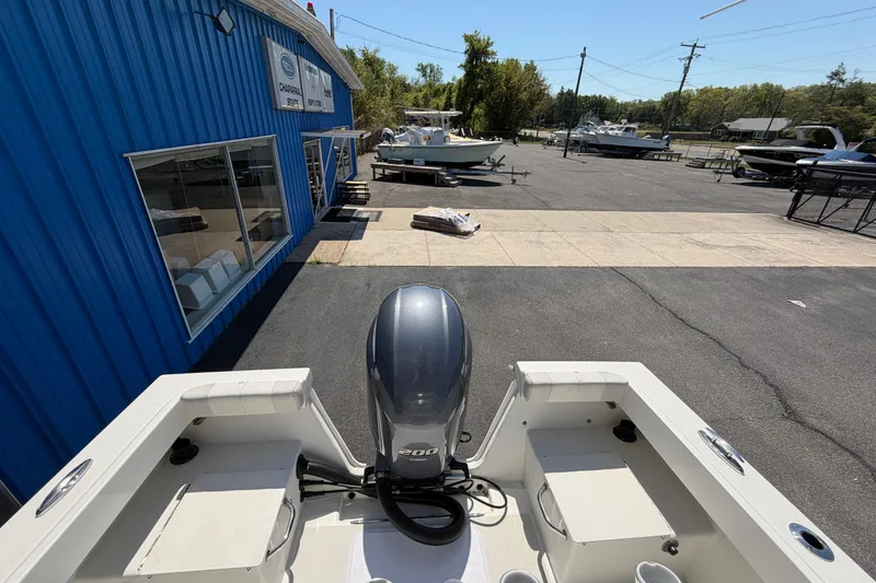 Slide: The Image of 2016 Parker 2100 Center Console boat at dealership, featuring a powerful outboard motor. - 19