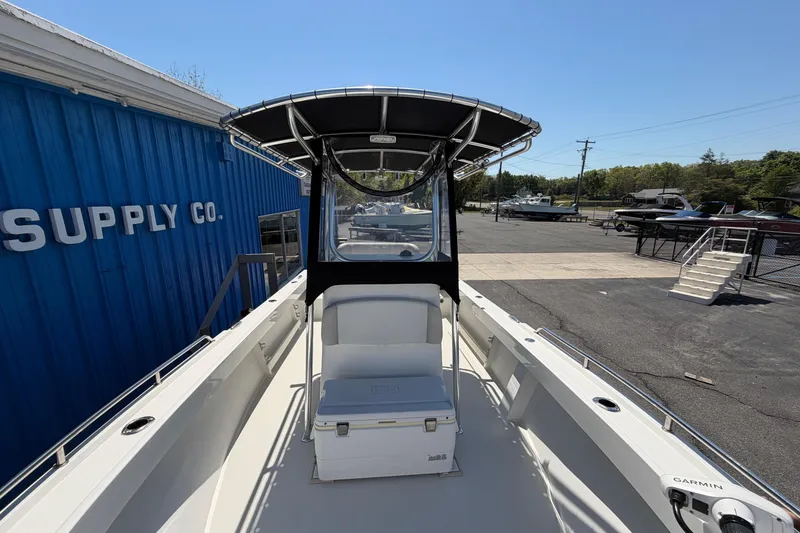 Slide: The Image of 2016 Parker 2100 Center Console boat at a marina, featuring a sleek design and T-top. - 5