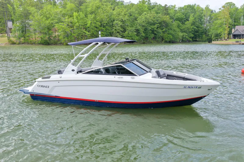 The Image of 2023 Cobalt R6 boat on a serene lake with lush green surroundings. - 1