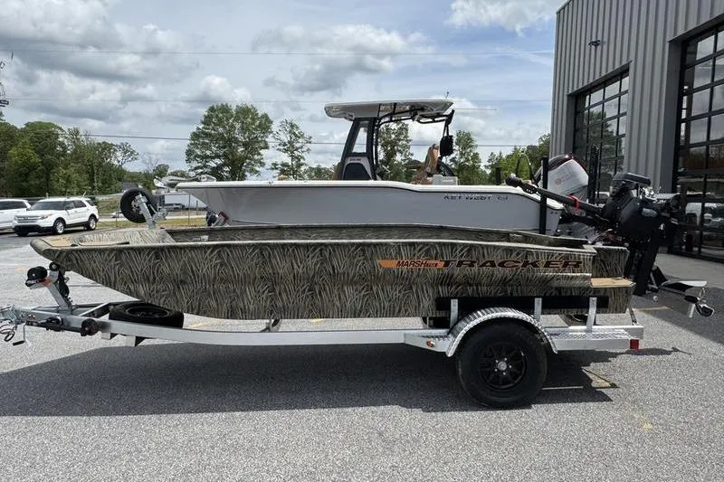 The Image of 2026 Tracker Grizzly 1756 T Marsh boat on trailer, parked outdoors near a building. - 1