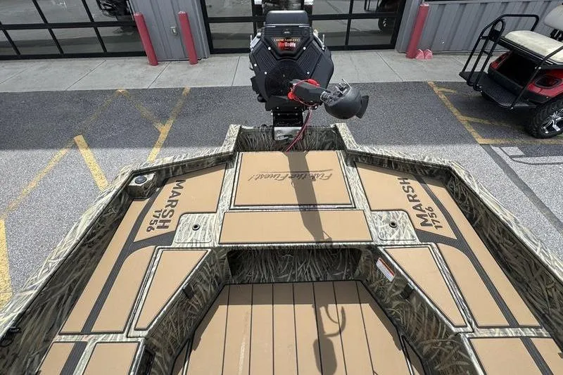 Slide: The Image of 2026 Tracker Grizzly 1756 T Marsh boat interior with camo design and motor. - 12