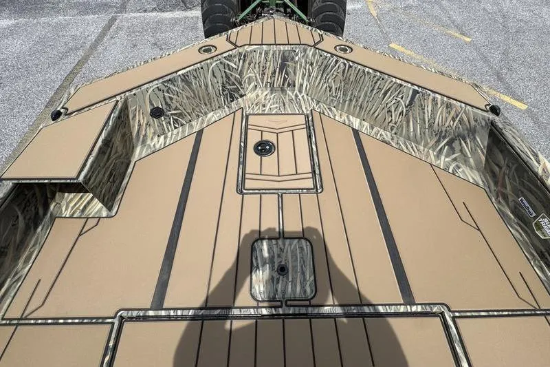Slide: The Image of 2026 Tracker Grizzly 1756 T Marsh boat deck with camouflage design and storage compartments. - 7