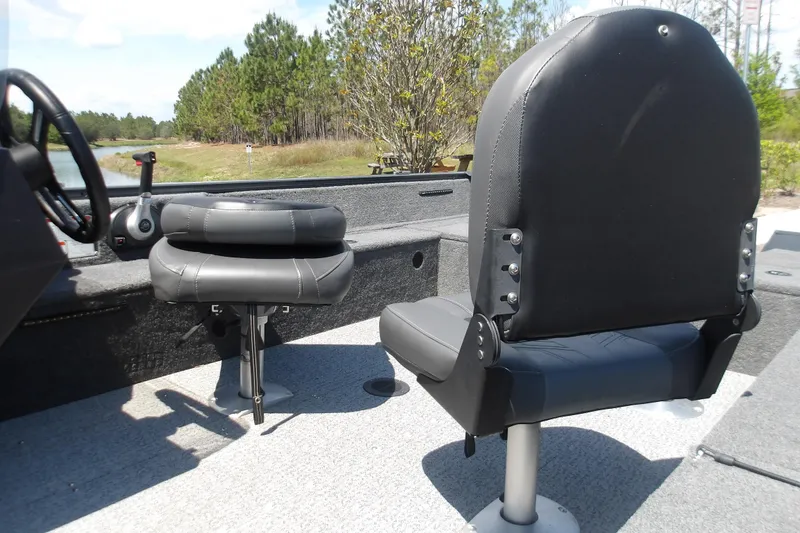 Slide: The Image of 2021 Tracker Pro Guide V-16 SC boat interior with gray seating and steering controls. - 6