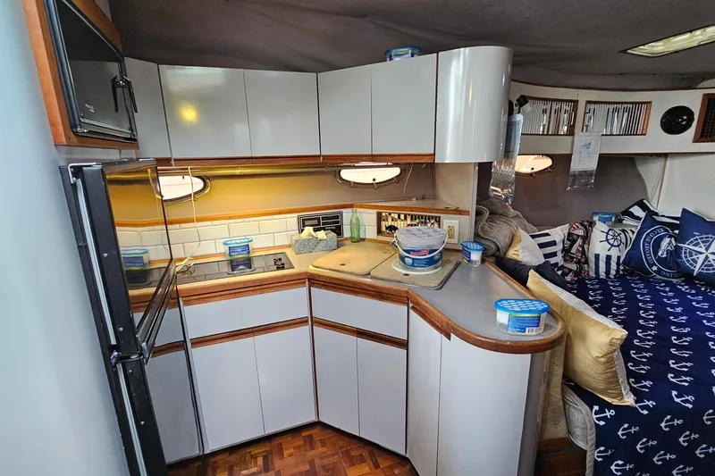 Slide: The Image of 1988 Regal Commodore 360 yacht interior with kitchenette and cozy seating area. - 11