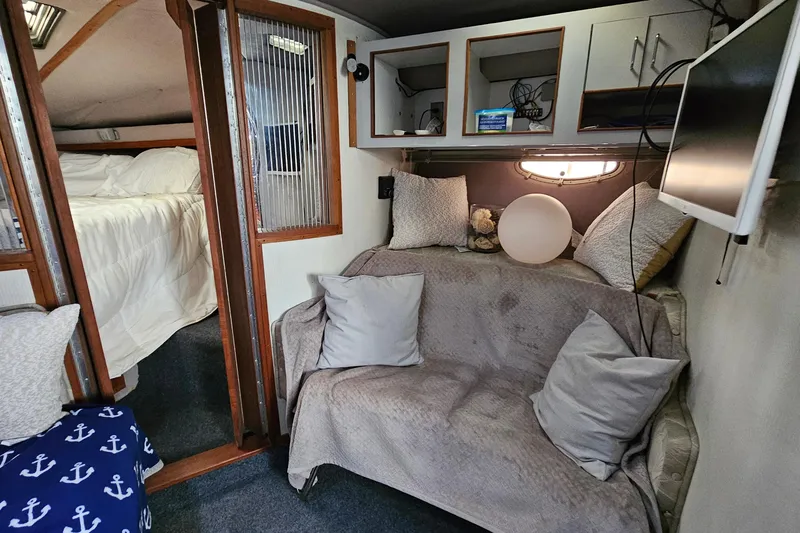 Slide: The Image of Cozy interior of a 1988 Regal Commodore 360 boat with seating and a small bedroom. - 13