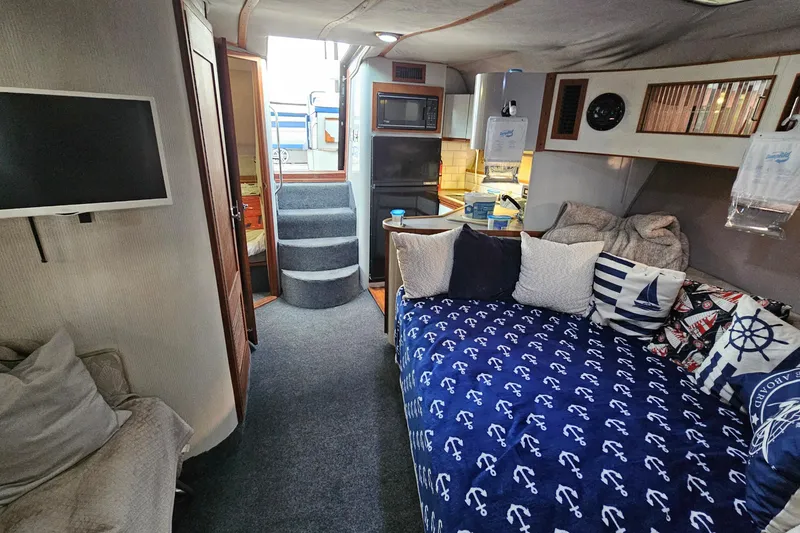Slide: The Image of Interior of 1988 Regal Commodore 360 boat with cozy seating and nautical decor. - 15