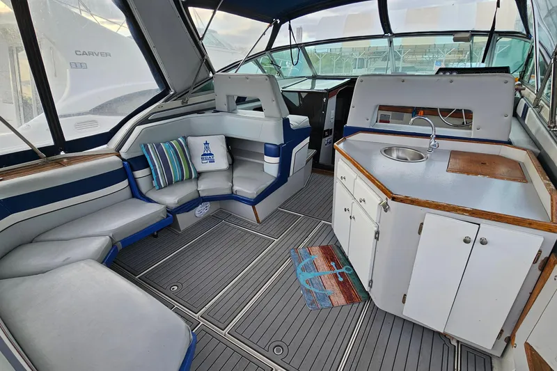 Slide: The Image of 1988 Regal Commodore 360 boat interior with seating, kitchenette, and nautical decor. - 4
