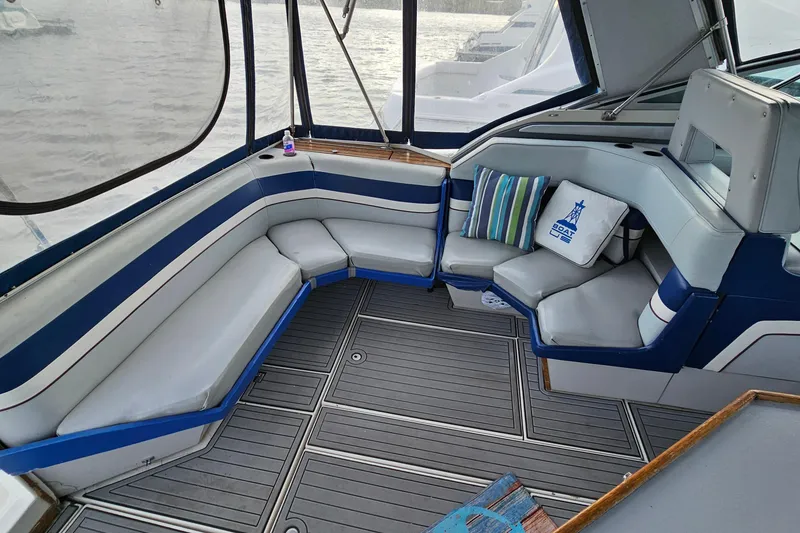 Slide: The Image of 1988 Regal Commodore 360 boat interior with blue and white seating, striped pillows, and gray flooring. - 5