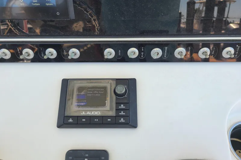 Slide: The Image of Control panel of a 2021 Sportsman Open 242 Center Console boat with JL Audio system. - 14