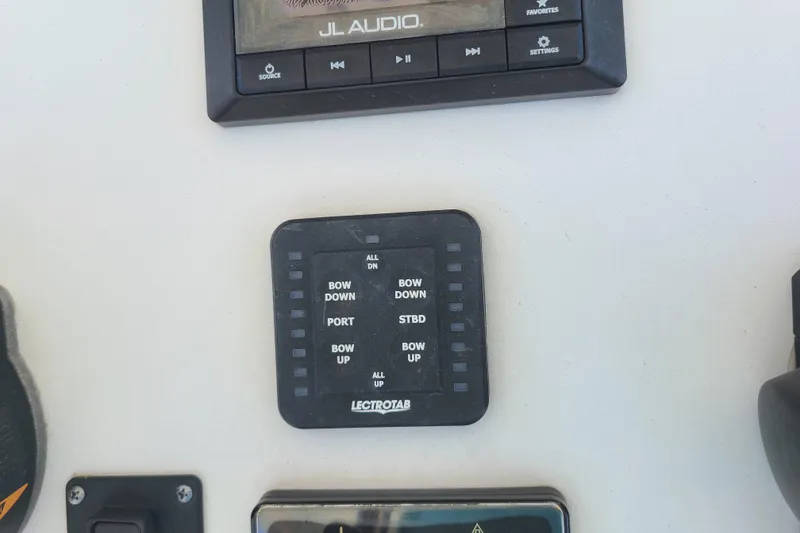 Slide: The Image of Control panel of a 2021 Sportsman Open 242 Center Console boat with JL Audio system. - 15