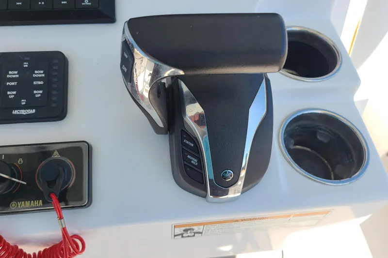 Slide: The Image of Throttle controls on a 2021 Sportsman Open 242 Center Console boat dashboard. - 16