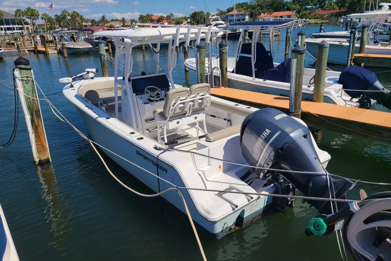 Slide: The Image of 2021 Sportsman Open 242 Center Console boat docked in marina with Yamaha engine. - 2