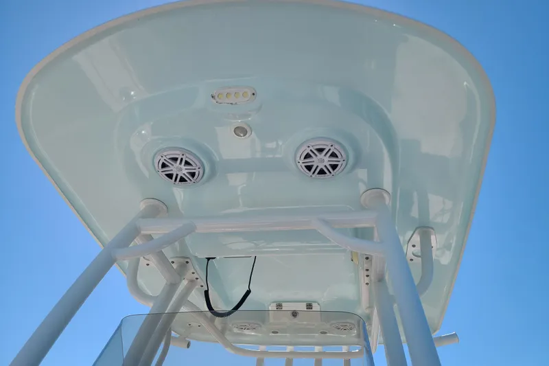 Slide: The Image of 2021 Sportsman Open 242 Center Console T-top with speakers against blue sky. - 21