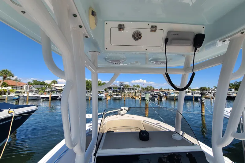 Slide: The Image of 2021 Sportsman Open 242 Center Console boat docked at a marina under clear blue skies. - 22