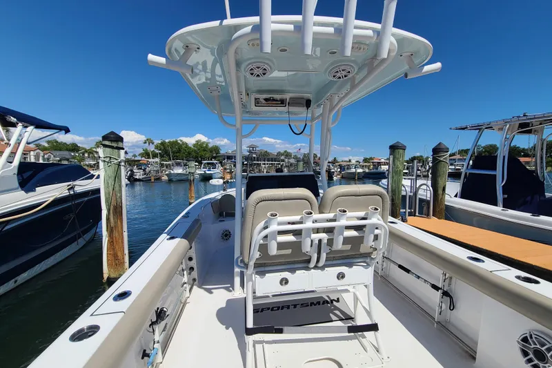 Slide: The Image of 2021 Sportsman Open 242 Center Console boat docked at marina under clear blue sky. - 23