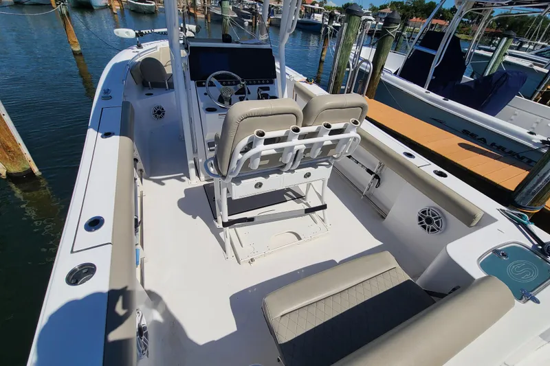 Slide: The Image of 2021 Sportsman Open 242 Center Console boat interior at marina, featuring seating and control panel. - 24