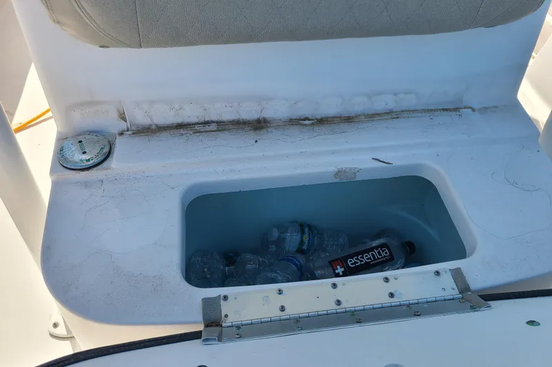 Slide: The Image of Storage compartment with water bottles on a 2021 Sportsman Open 242 Center Console boat. - 26