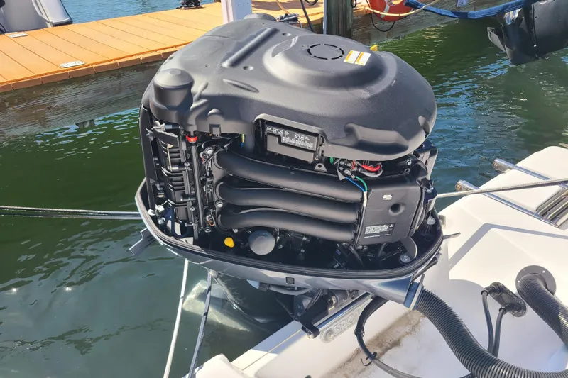 Slide: The Image of Outboard motor of a 2021 Sportsman Open 242 Center Console boat at a dock. - 27