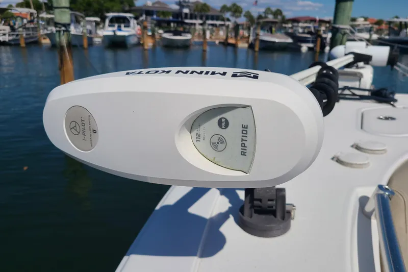Slide: The Image of Minn Kota Riptide motor on 2021 Sportsman Open 242 Center Console boat at marina. - 6