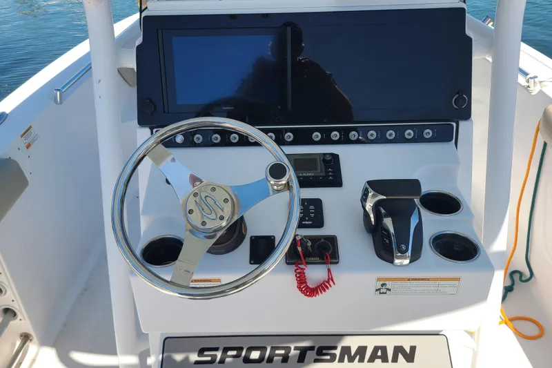 Slide: The Image of 2021 Sportsman Open 242 Center Console boat dashboard with steering wheel and controls. - 9
