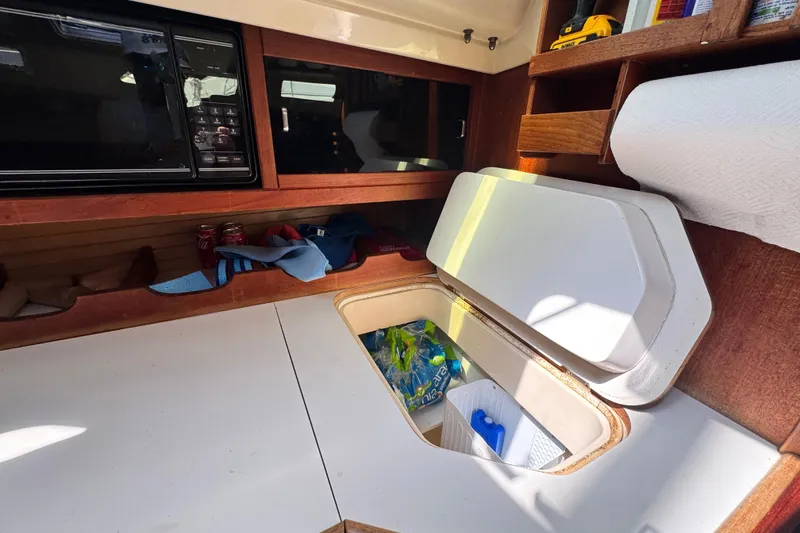 Slide: The Image of Interior of 1990 Catalina 42 MkII sailboat with storage compartments and microwave. - 16