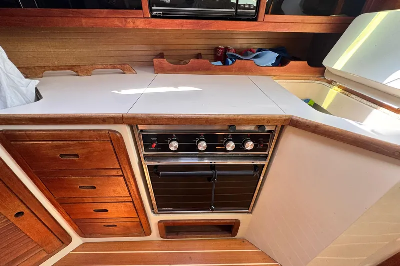 Slide: The Image of Galley kitchen in 1990 Catalina 42 MkII sailboat with stove and wooden cabinetry. - 17