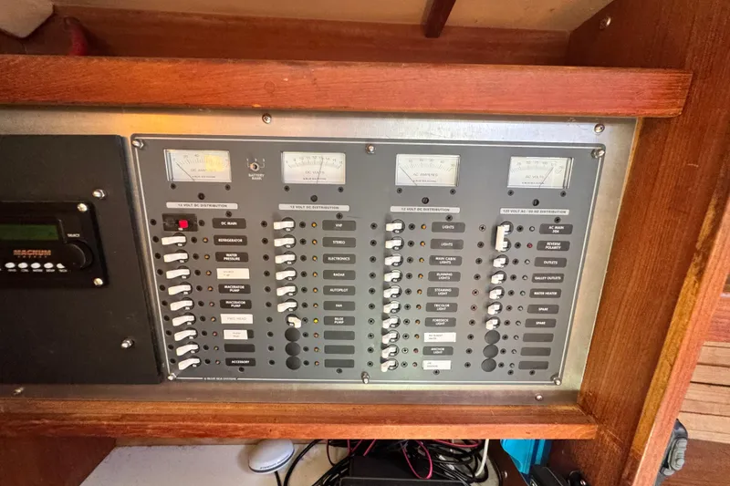 Slide: The Image of Electrical control panel on a 1990 Catalina 42 MkII sailboat, featuring various switches and gauges. - 18