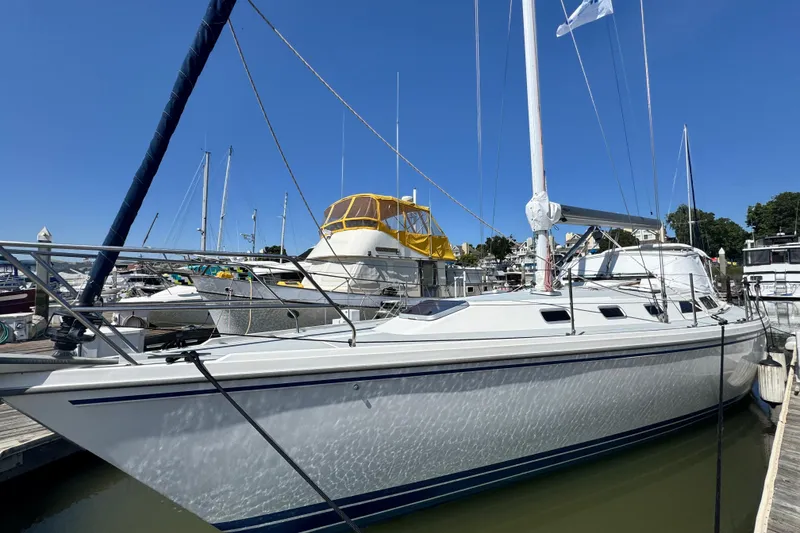 The Image of 1990 Catalina 42 MkII sailboat docked at marina under clear blue sky. - 2