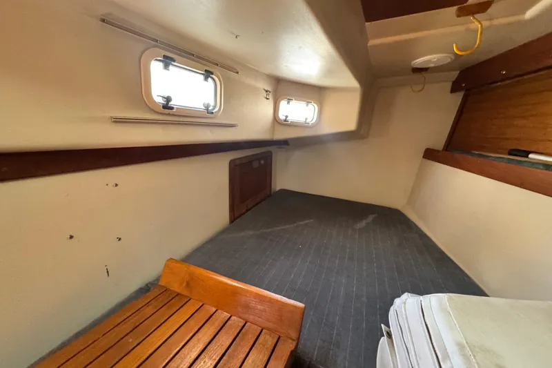 Slide: The Image of Interior cabin of a 1990 Catalina 42 MkII sailboat, featuring wooden accents and portholes. - 23