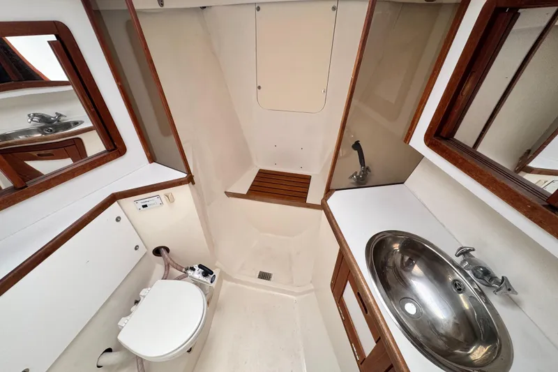 Slide: The Image of Interior of 1990 Catalina 42 MkII yacht bathroom with sink, toilet, and wooden accents. - 27