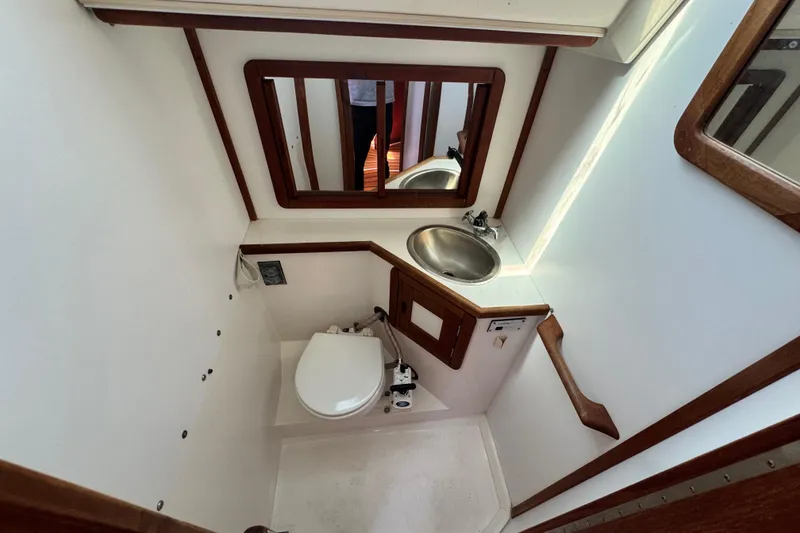 Slide: The Image of Compact bathroom in a 1990 Catalina 42 MkII sailboat with sink, toilet, and mirror. - 30