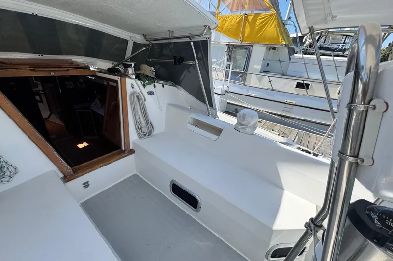 Slide: The Image of Cockpit of a 1990 Catalina 42 MkII sailboat, featuring seating and entryway. - 9